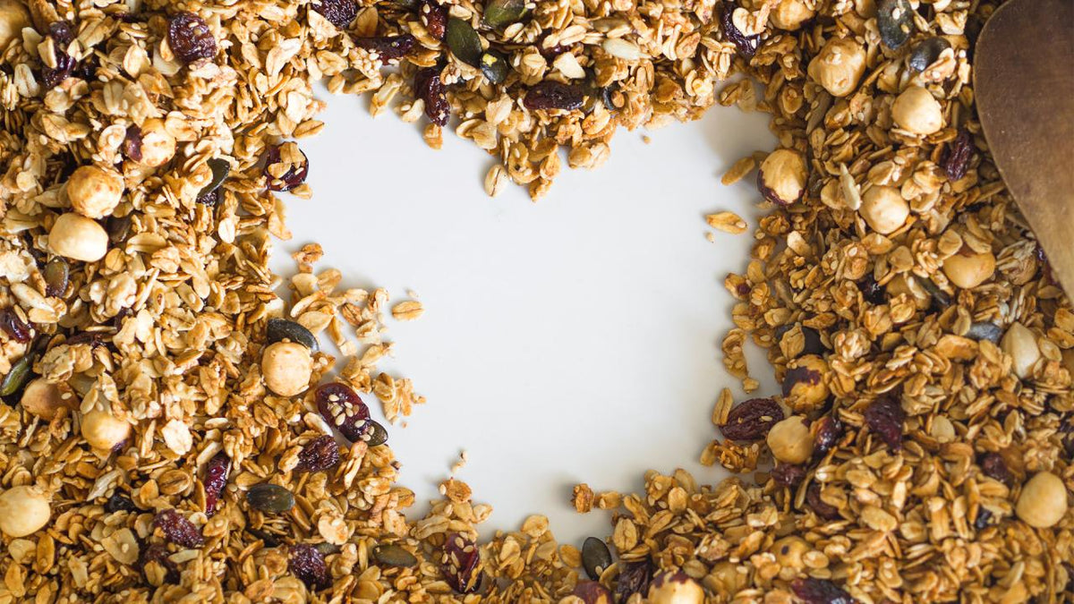Granola arranged in a heart shape with a white background.