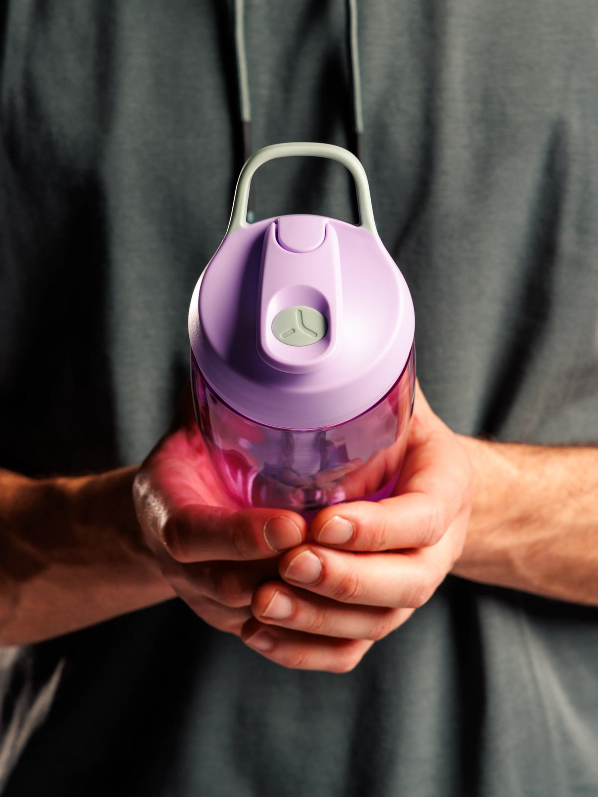 Hands holding a lilac PROMIXX Pursuit shaker bottle