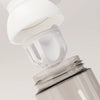 PROMIXX Ecozen Hybrid water bottle in Ceramic White / Cool Gray — close-up of the perforated dome mixing agitator lifting away from the bottle.