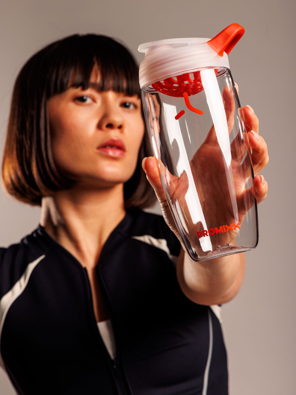 Pursuit shaker in Clear / Burnt Orange held by an athlete