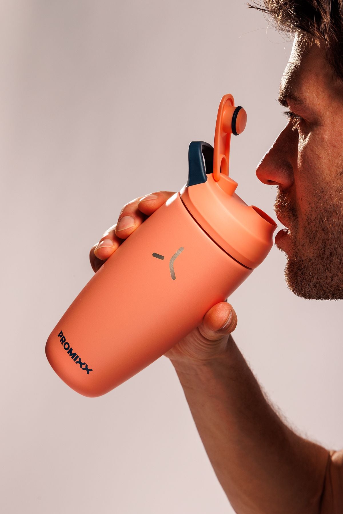 Pursuit shaker in Coral / Midnight Blue held by an athlete
