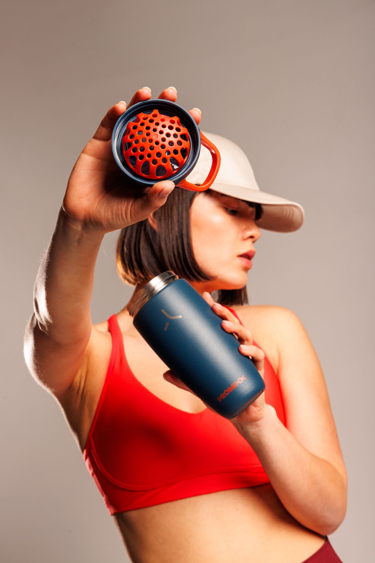 Athlete lifting the burnt-orange agitator above a Midnight Blue Pursuit shaker